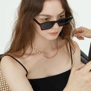 Elegant 18K gold-plated titanium coffee bean necklace worn by a fashion model on a dark top