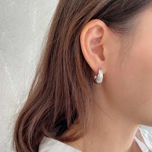 Detail shot of silver chunky hoop earrings featuring vertical embossed stripe texture