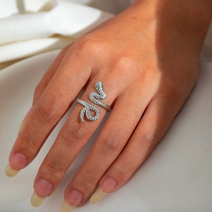 Macro shot of silver titanium steel snake ring with scale texture on model's finger