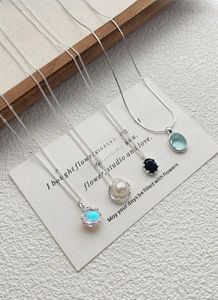 Detail view of S925 silver necklaces with opal, pearl, black and blue gemstone pendants