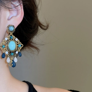 Detailed close-up of vintage resin diamond rhombus stud earring on a model's ear