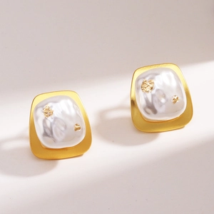 Vue détaillée de boucles d'oreilles fleur plaquées or 18k avec perles et accents de feuille d'or