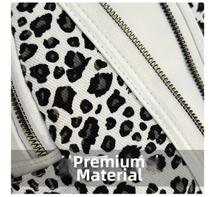 Detail view of leopard print canvas bag with white leather trim and gold metal zipper