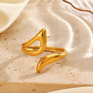 Minimalist gold open ring featuring fluid geometric curves on a natural stone pedestal