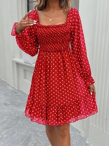 Detail of red polka dot dress featuring a square neckline and smocked elastic bodice