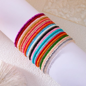 Colorful seed bead bracelet set on a white display with bohemian coral accents