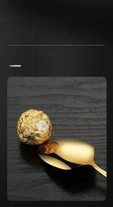 Close-up of golden stainless steel spoon with mirror finish and slim waist handle design