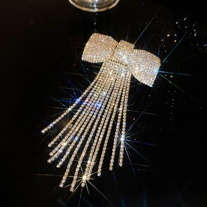 Détail d'une pince à cheveux avec nœud en cristal et de longs glands scintillants
