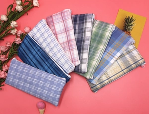 Detailed top view of various colorful checkered canvas pencil cases with zipper closure