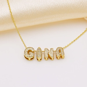 Macro shot of GINA gold pendant necklace featuring micro-pave clear zircon crystal stones