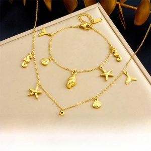 Close-up of gold-plated starfish and seahorse ocean charms on jewelry set