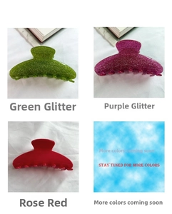 Close-up of large acetate hair claws in glitter green, fuchsia, and solid rose red finishes