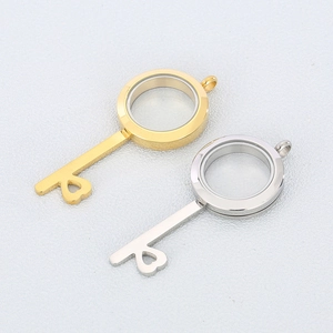 Detail of key-shaped stainless steel locket pendants in gold and silver finish
