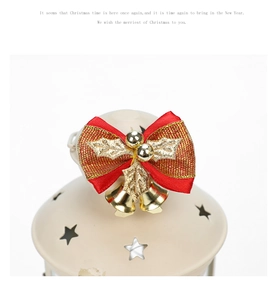 Détail d'un nœud de Noël rouge avec clochettes dorées et baies sur une lanterne décor