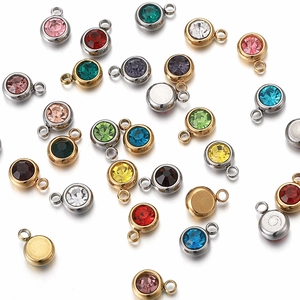Detailed view of colorful stainless steel round birthstone charms in gold and silver settings