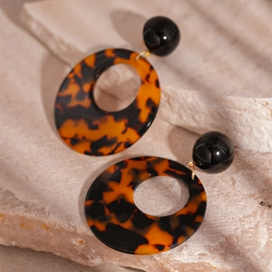 Vintage chunky resin leopard print hoop earrings with black studs on stone background
