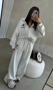 Détail d'un ensemble de jogging gris à capuche avec broderie et pantalon large décontracté