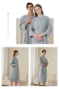 Macro detail of light grey waffle weave bathrobe with white piping and waist tie belt