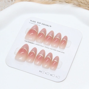 Unghie finte cat-eye sfumate rosa con dettaglio linea dorata su espositore bianco