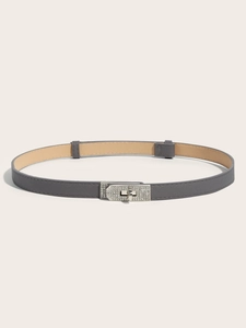 Detail of grey thin faux leather belt with sparkling rhinestone buckle and cross-grain texture