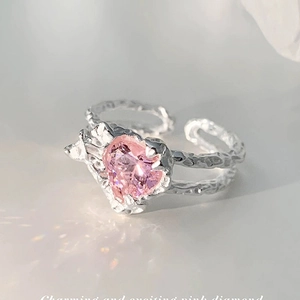 Macro shot of silver ring with hammered texture and a heart-shaped pink zircon