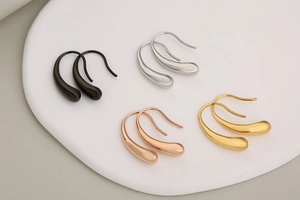 Detail view of teardrop hook earrings in polished black, silver, gold, and rose gold finish