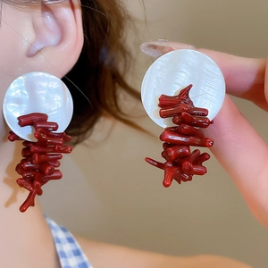 Detail of model wearing red coral branch earrings with white shell studs