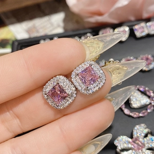 Macro view of square pink gemstone stud earrings with double halo zirconia setting