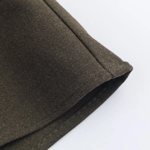 Detail of dark olive green dress fabric showing fine texture and double stitching
