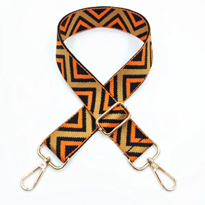 Close-up of zigzag striped wide shoulder strap with polished gold metal lobster clasps