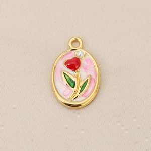 Detailed macro view of 18K gold plated oval tulip pendant with red enamel and pearl