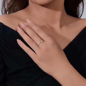 Close-up of a gold wheat ear ring with sparkling diamonds worn on a woman finger