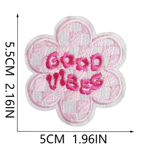 Detail showing pink checkered flower embroidery patch with Good Vibes text and 5.5cm size