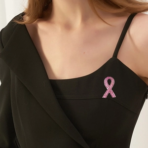 Rosa Schleife Brosche mit Kristallen auf schwarzem Kleid für Brustkrebs-Bewusstsein
