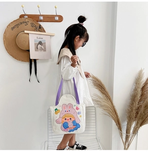 Detail of white canvas tote bag with purple handles and cute cartoon girl illustration