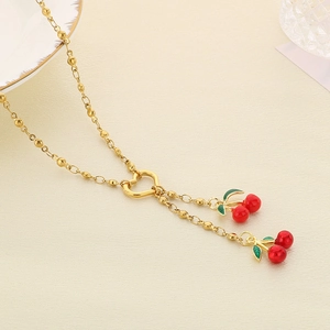 Close-up of gold titanium steel necklace featuring red cherry heart pendants on beige leather