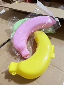 Three colorful plastic banana shaped storage cases in yellow, pink and green finishes