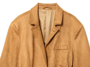 Dettaglio del bavero e del taschino di un blazer in camoscio sintetico marrone
