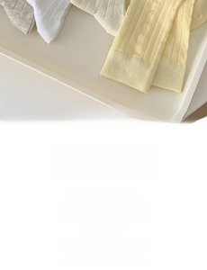Detailed view of ribbed knit cotton socks with cute ribbon bows in soft cream colors