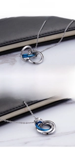 Close-up of interlocking stainless steel rings with blue accent and sparkling crystals