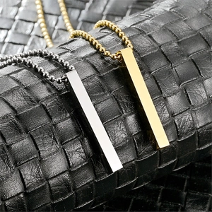 Close-up of gold and silver bar necklaces on leather, featuring high-polish vertical pendants