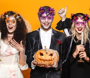 Close-up of Halloween novelty glasses with colorful tinsel and festive cartoon icons