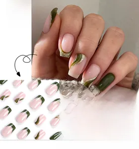 Dettaglio di unghie finte verde scuro con glitter dorati ed effetto shimmer