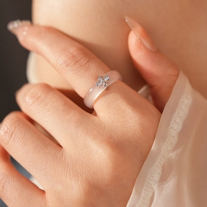 Close-up of translucent pink chalcedony ring featuring a silver metal cross inlay