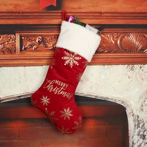 Close-up of red velvet Christmas stocking with gold snowflakes and Merry Christmas text