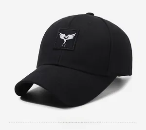 Close-up of black baseball cap showing cotton twill texture and white wing embroidery