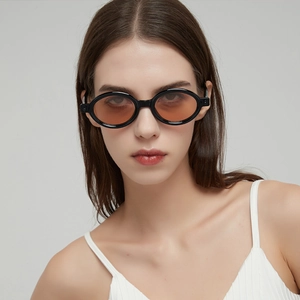 Fashionable retro oval sunglasses with black frames and translucent tea orange lenses
