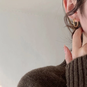 Minimalist gold knot hoop earrings in S925 sterling silver worn by a model