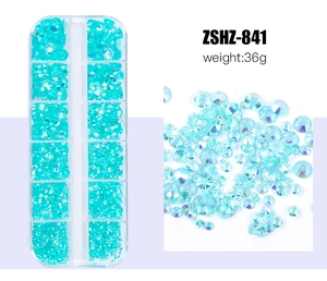 Detailed view of teal resin flatback rhinestones in a 12-grid organizer box for nail art