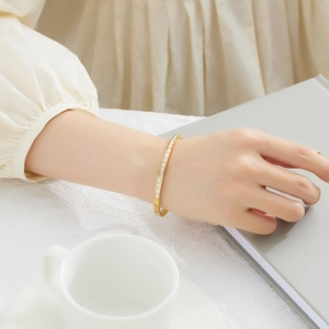 Close-up of gold titanium steel bracelet with square zircons on model's wrist